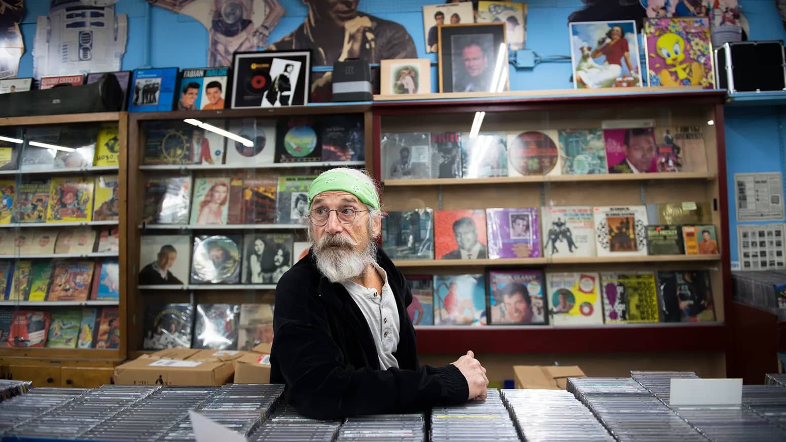 Joe DiPietro watches customers shop at his record store, Howard & Nan's